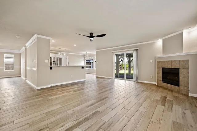 a view of a livingroom with wooden floor and a kitchen space