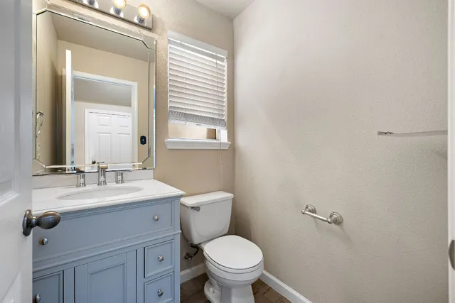 a view of an empty room with wooden floor fireplace and a window