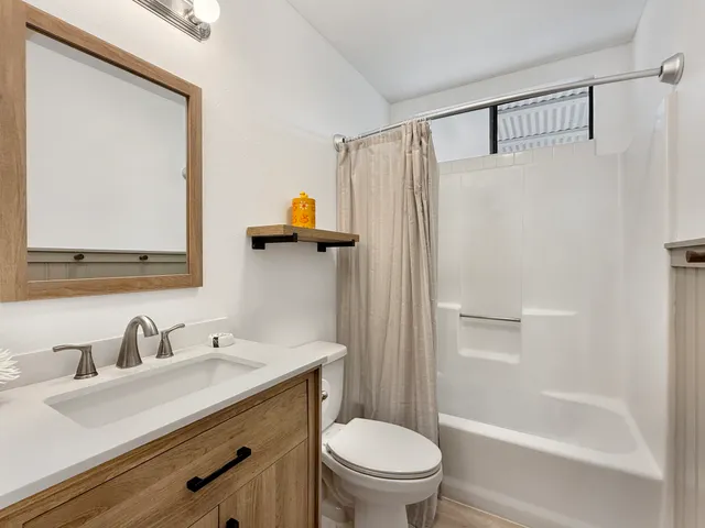 a bathroom with a sink mirror toilet and shower