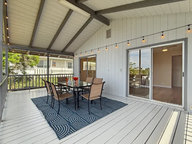 a view of a dining room with wooden floor and outdoor space