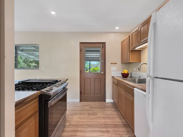 a kitchen with stainless steel appliances a stove a sink and a refrigerator
