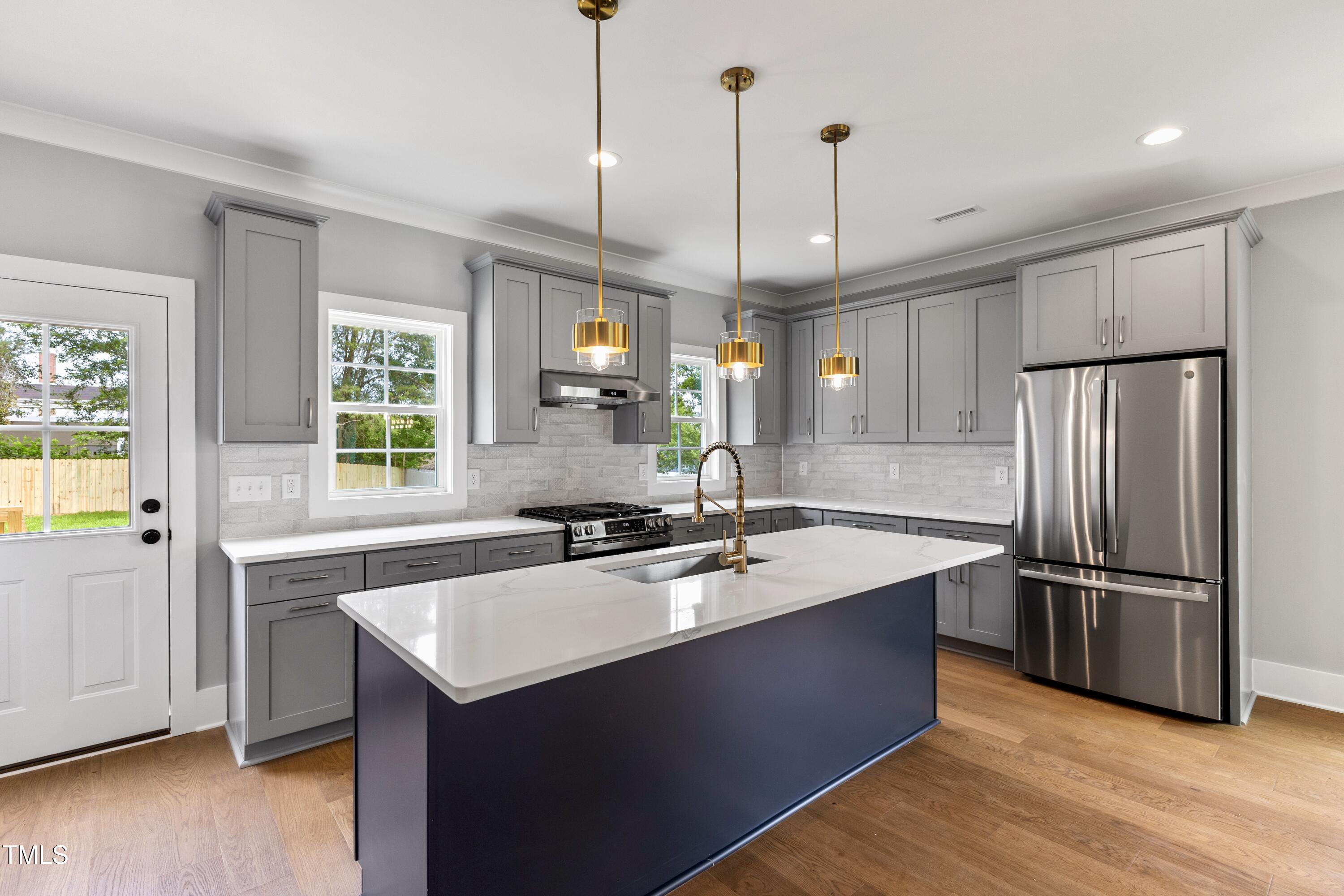 2521 Newbold Street Raleigh, NC 27603 - Photo 14 of 40 a kitchen with stainless steel appliances granite countertop a sink a stove and a refrigerator