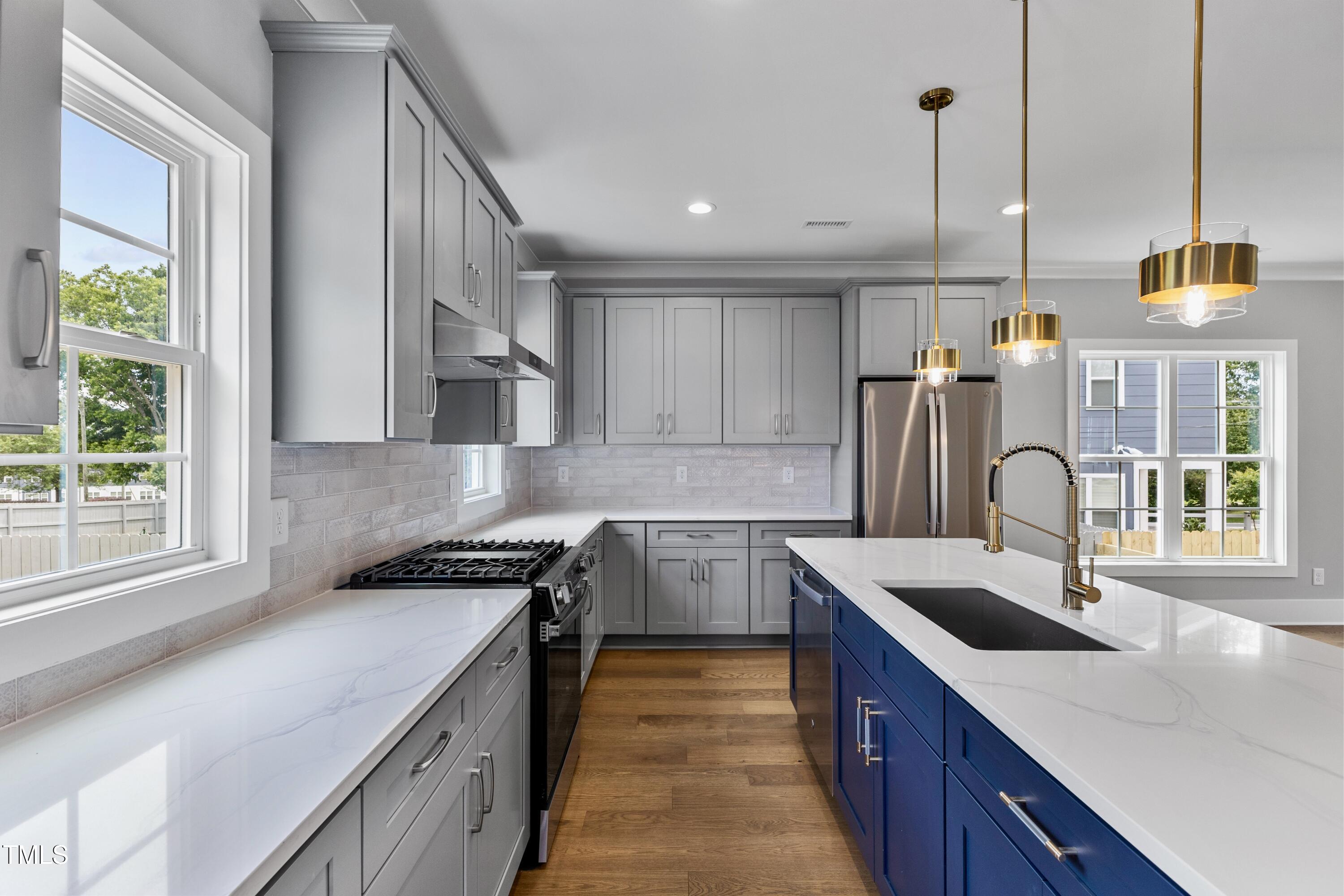 2521 Newbold Street Raleigh, NC 27603 - Photo 15 of 40 a kitchen that has a lot of cabinets in it and wooden floors