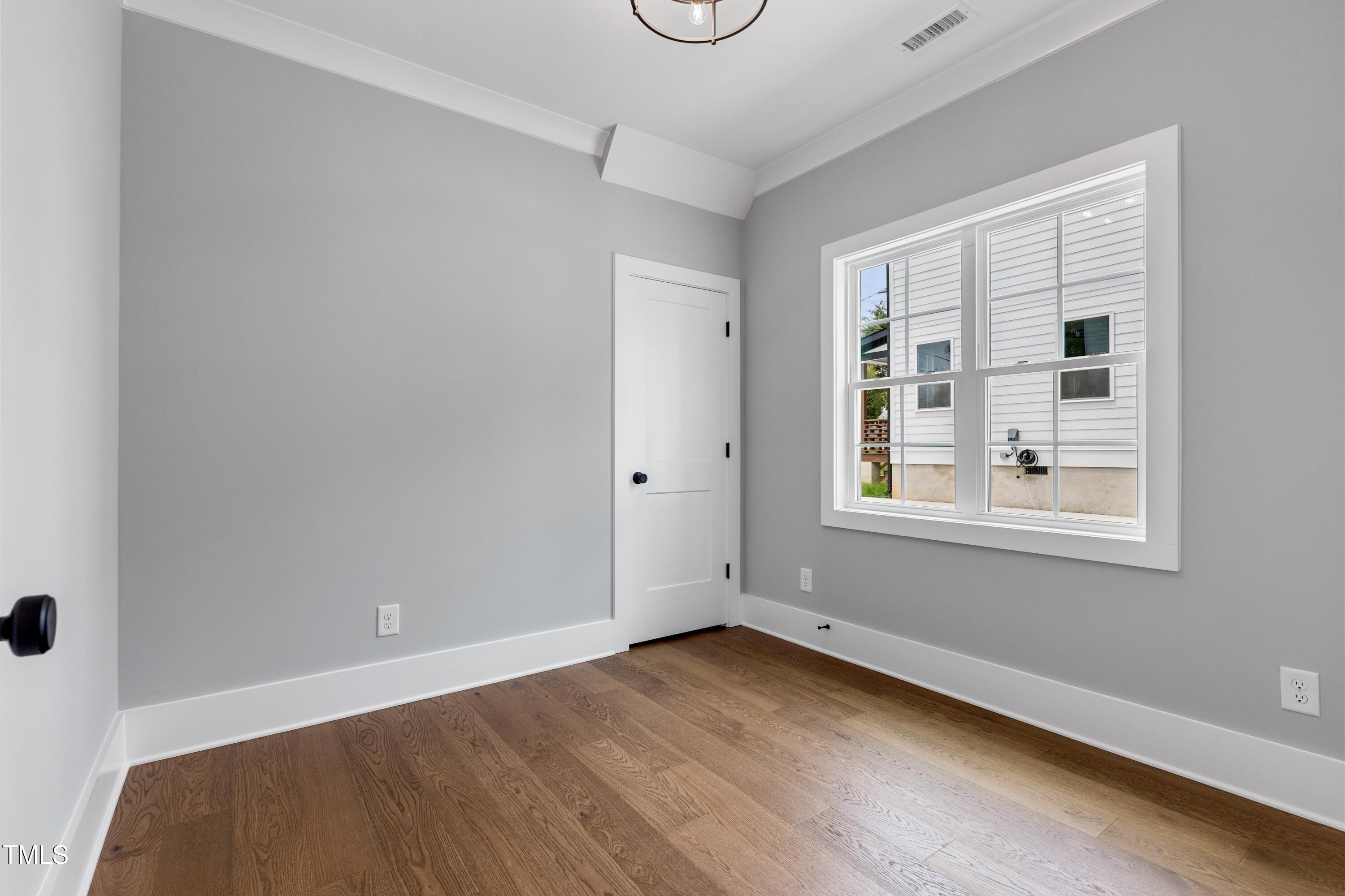 2521 Newbold Street Raleigh, NC 27603 - Photo 19 of 40 an empty room with wooden floor and windows
