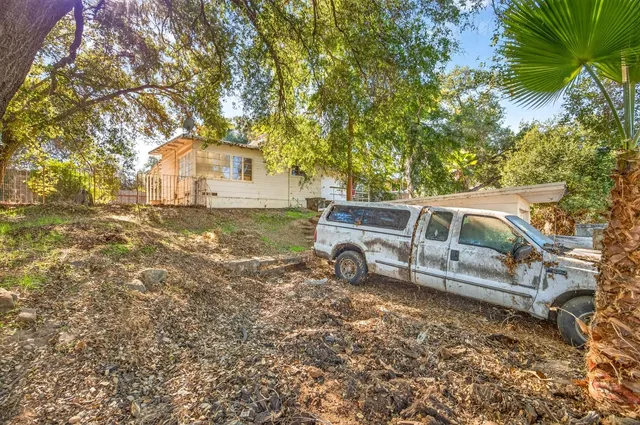 front view of a house with a garden and parking