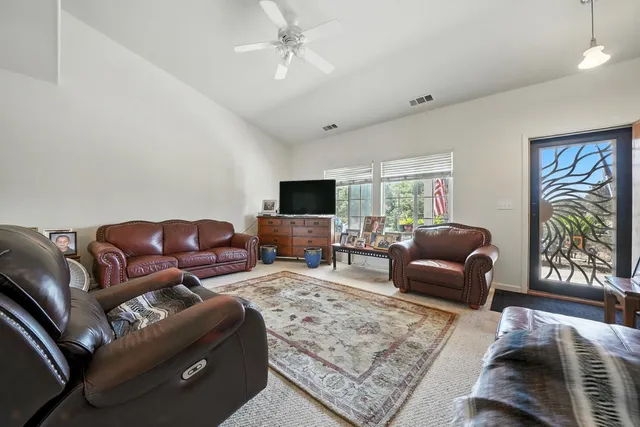 a living room with stainless steel appliances a rug and a painting on the wall