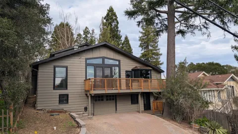 a front view of a house with a garden and trees