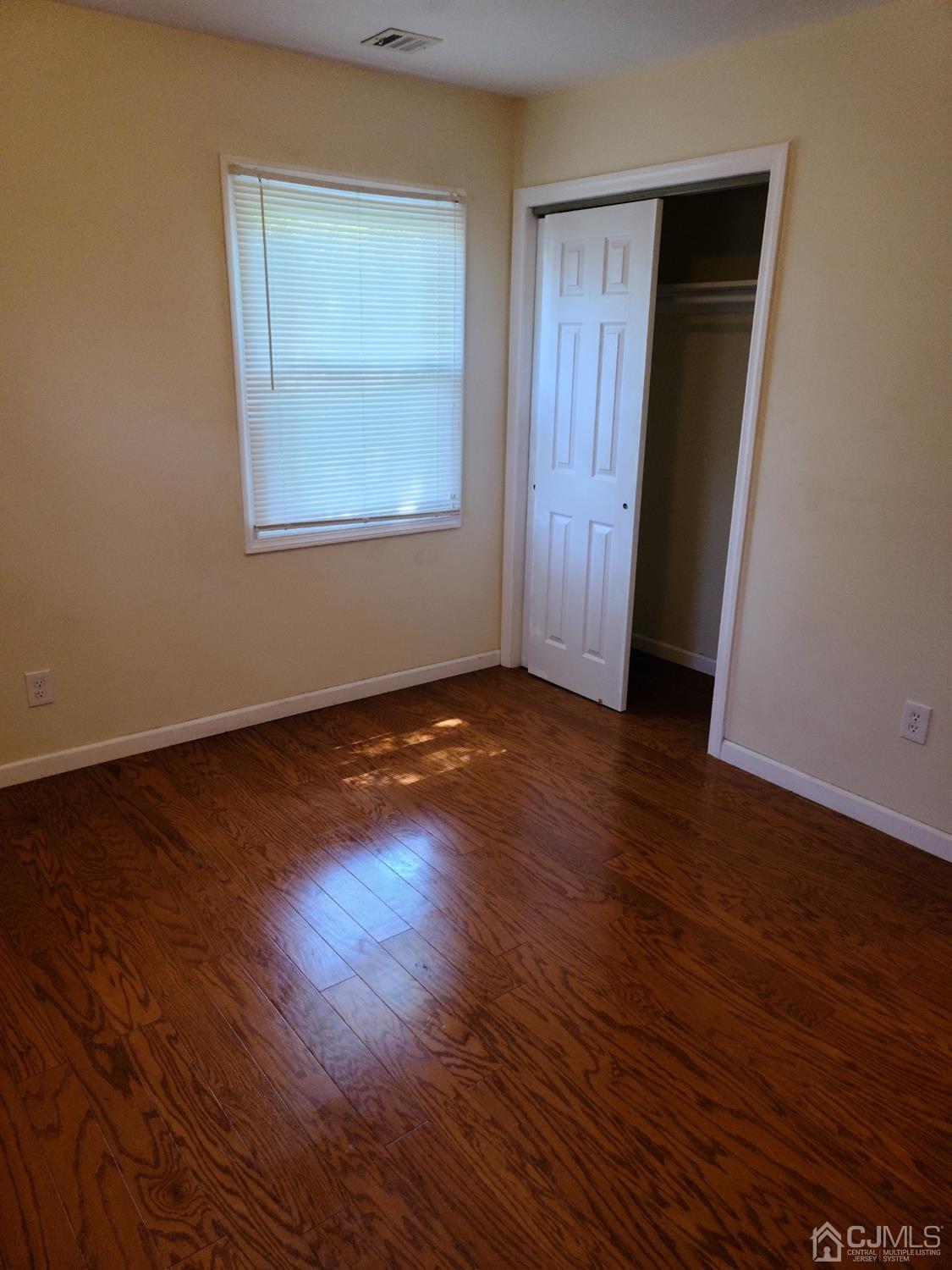 2 East Knollwood Road Edison, NJ 08817 - Photo 9 of 22 an empty room with wooden floor and windows