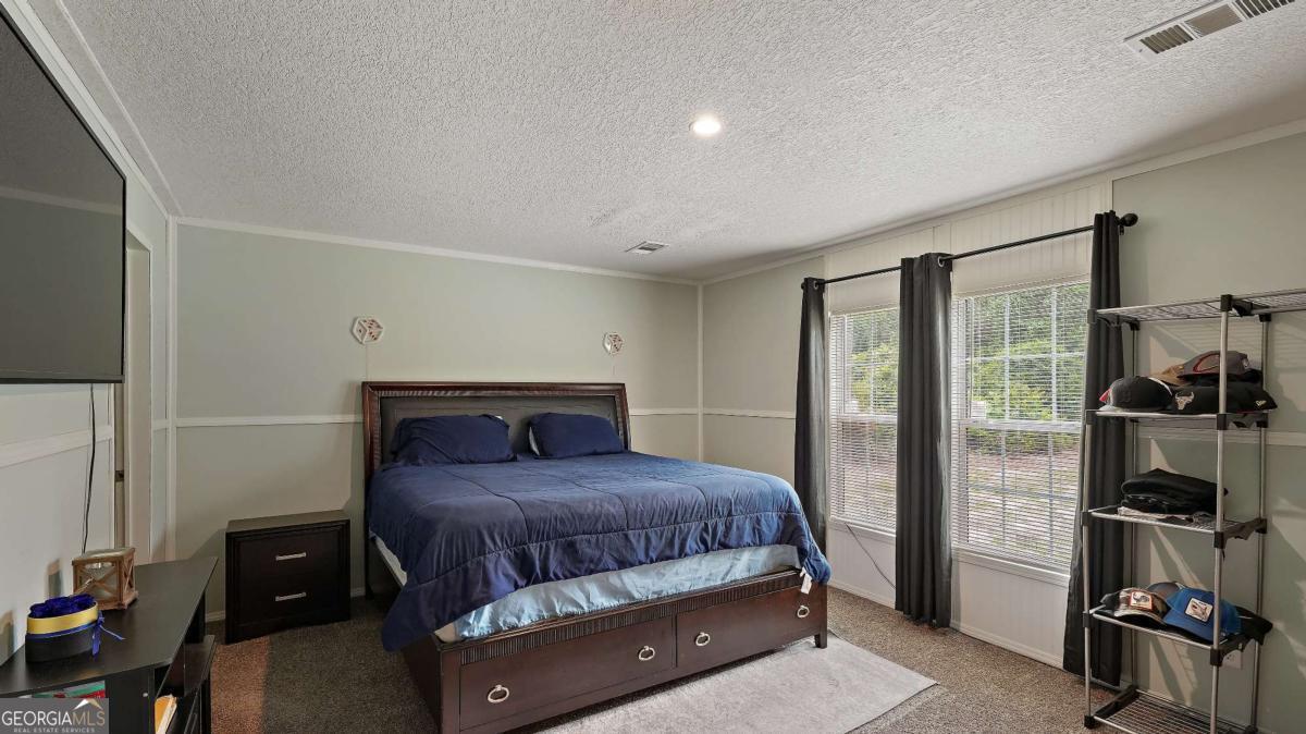 64 Sierra Road Jesup, GA 31545 - Photo 17 of 22 a bedroom with a bed and a walk in closet