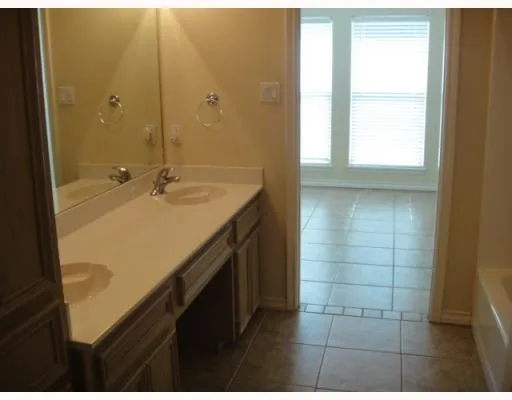 a bathroom with a granite countertop sink a mirror and a shower
