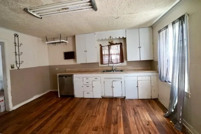 a kitchen with granite countertop white cabinets and white appliances
