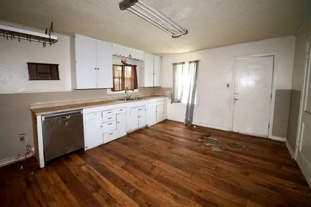a large kitchen with a wooden floor and cabinets