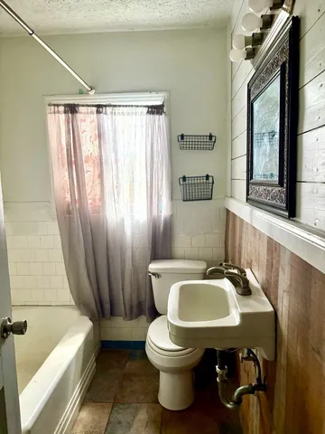 a bathroom with a sink a toilet and mirror