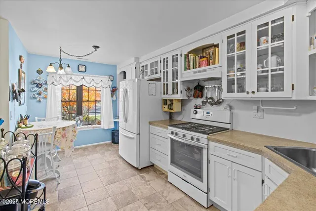 a kitchen with a stove top oven cabinets and a dining table