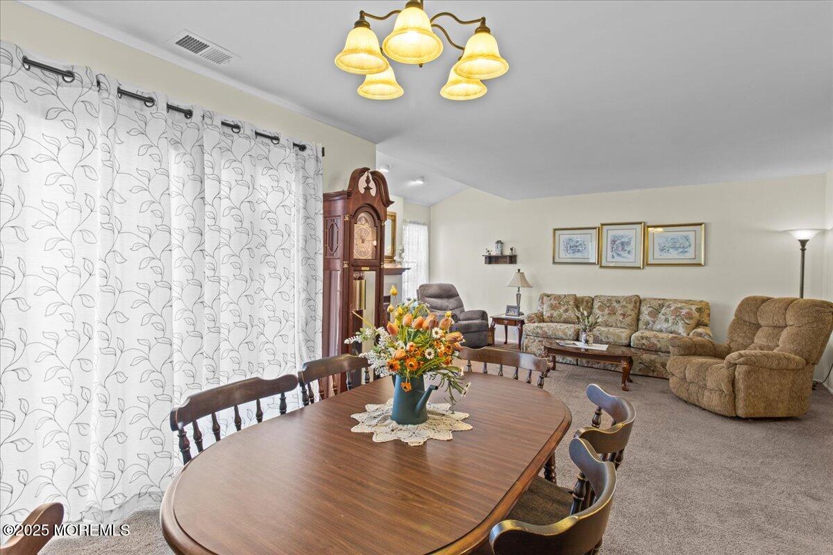 94 Paddock Court Oceanport, NJ 07757 - Photo 13 of 38 a living room with couches a dining table and a chandelier with wooden floor