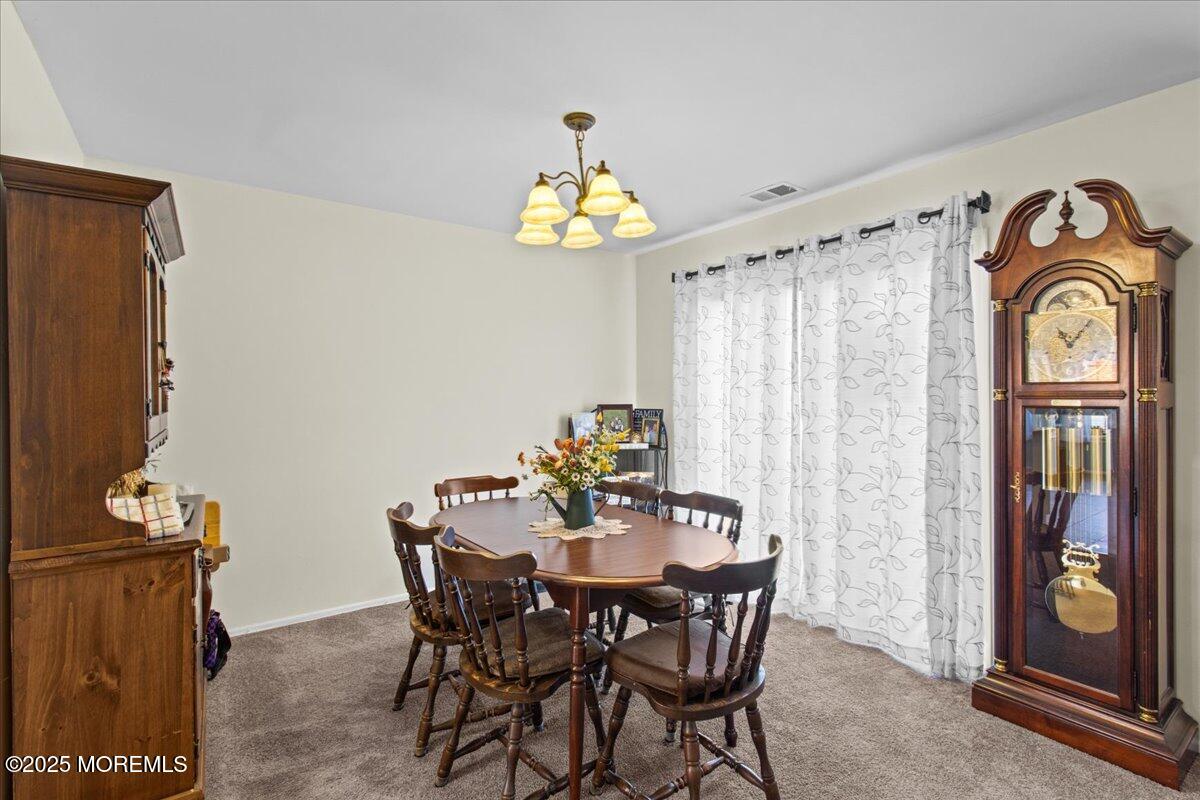 94 Paddock Court Oceanport, NJ 07757 - Photo 17 of 38 a view of a dining room with furniture wooden floor and a chandelier
