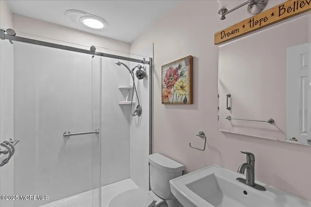 a bathroom with a shower sink vanity and toilet