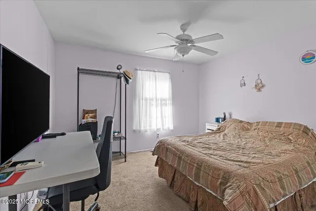 a bedroom with a bed tv and a window