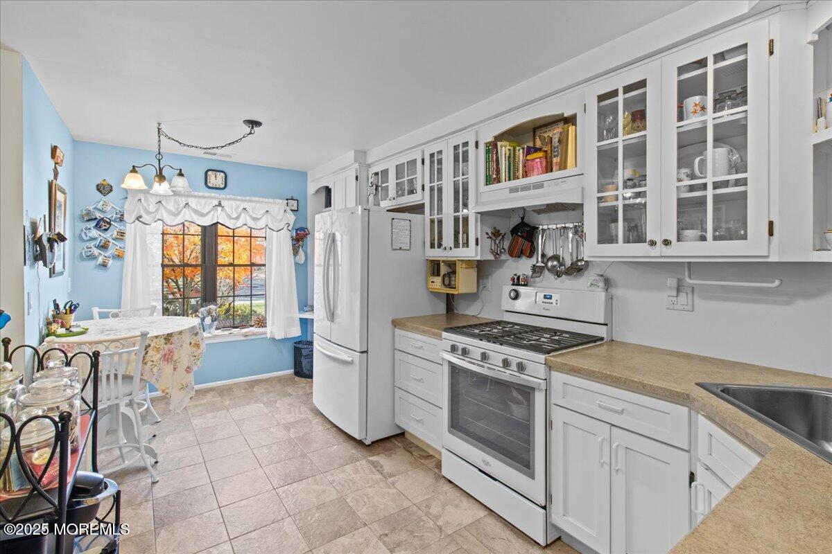 94 Paddock Court Oceanport, NJ 07757 - Photo 20 of 38 a kitchen with a stove top oven cabinets and a dining table