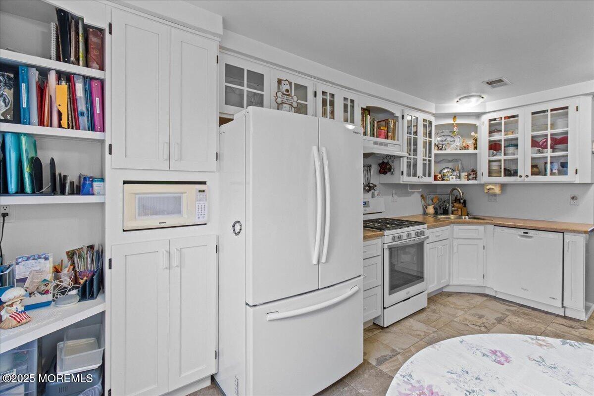 94 Paddock Court Oceanport, NJ 07757 - Photo 21 of 38 a white refrigerator freezer sitting inside of a kitchen with stainless steel appliances granite countertop a refrigerator and a sink