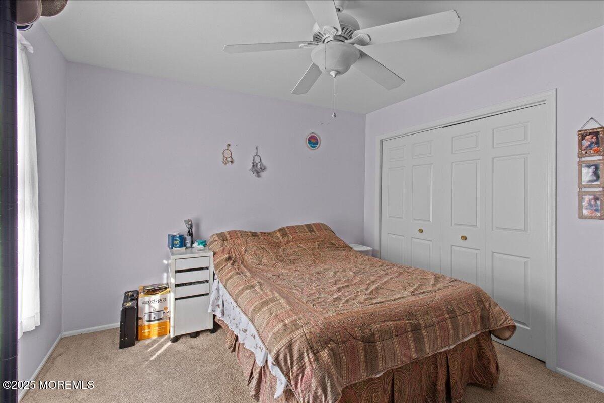 94 Paddock Court Oceanport, NJ 07757 - Photo 25 of 38 a bedroom with a bed a window and a chandelier