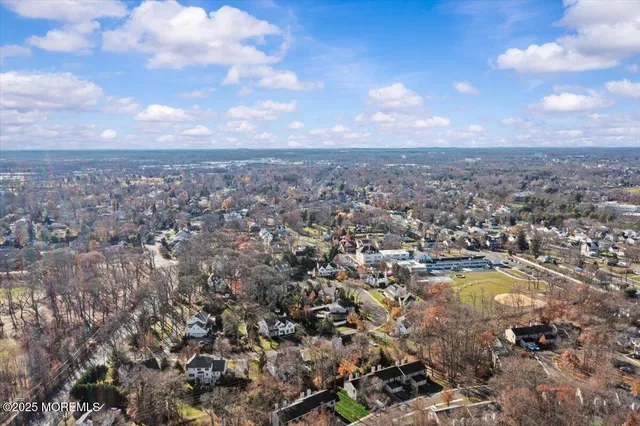 an aerial view of residential houses with outdoor space and trees