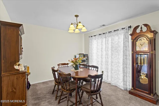 a view of a dining room with furniture wooden floor and a chandelier