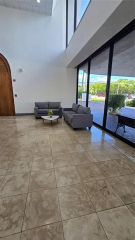 a living room with patio furniture and a floor to ceiling window