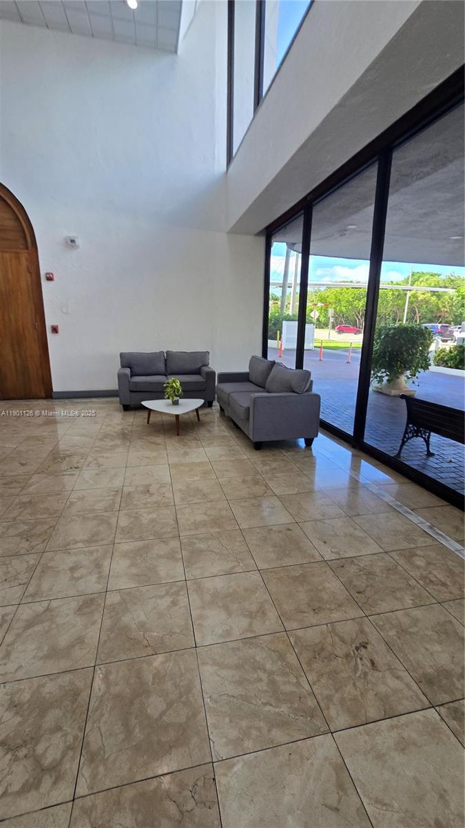 13499 Biscayne Boulevard, Unit 1103 North Miami, FL 33181 - Photo 15 of 20 a living room with patio furniture and a floor to ceiling window