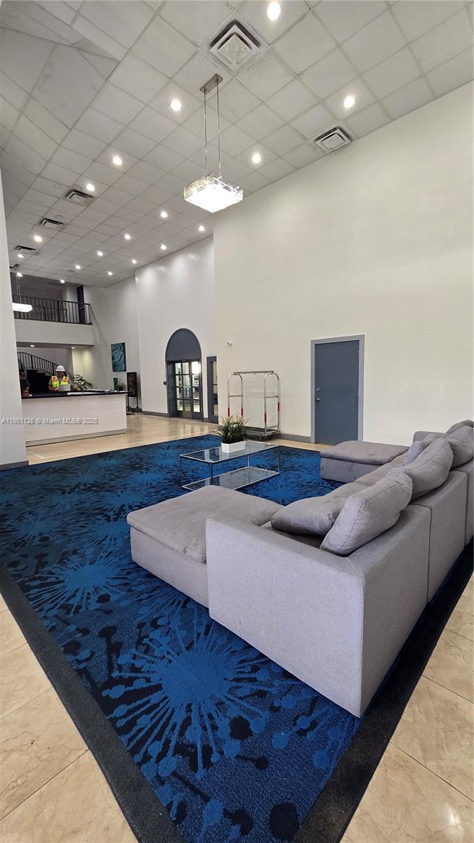 13499 Biscayne Boulevard, Unit 1103 North Miami, FL 33181 - Photo 18 of 20 a living room with furniture and a chandelier