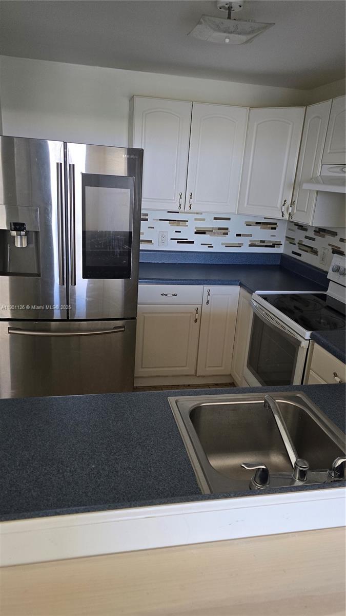 13499 Biscayne Boulevard, Unit 1103 North Miami, FL 33181 - Photo 4 of 20 a kitchen with a sink and white cabinets