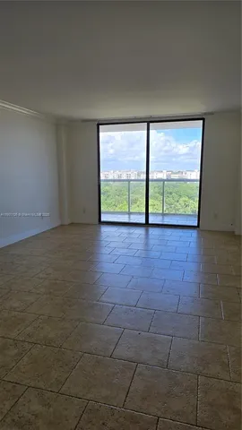 a view of an empty room with a floor to ceiling window and an empty room