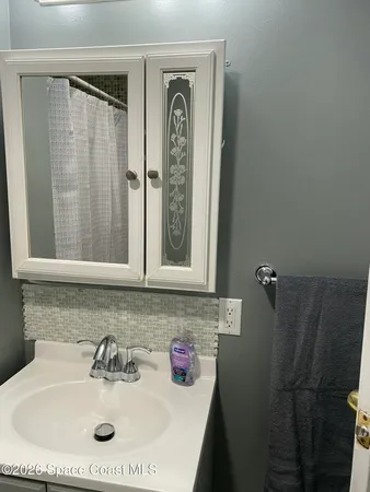 a bathroom with a sink a mirror and shower