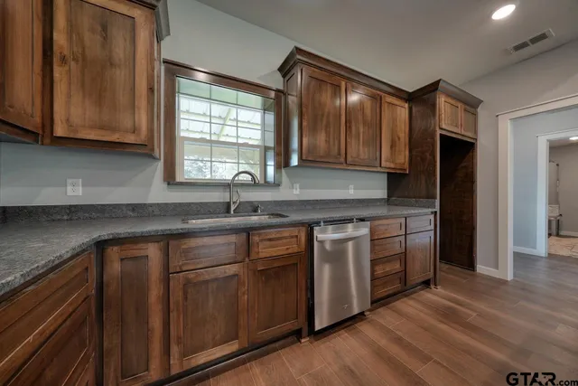 a kitchen with stainless steel appliances granite countertop a sink stove and cabinets