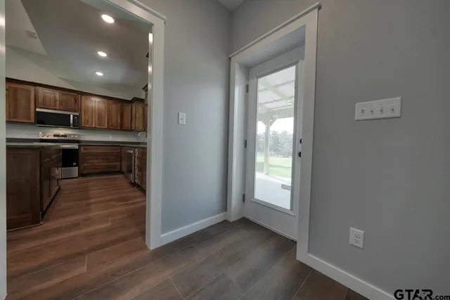 an empty room with wooden floor and a ceiling fan
