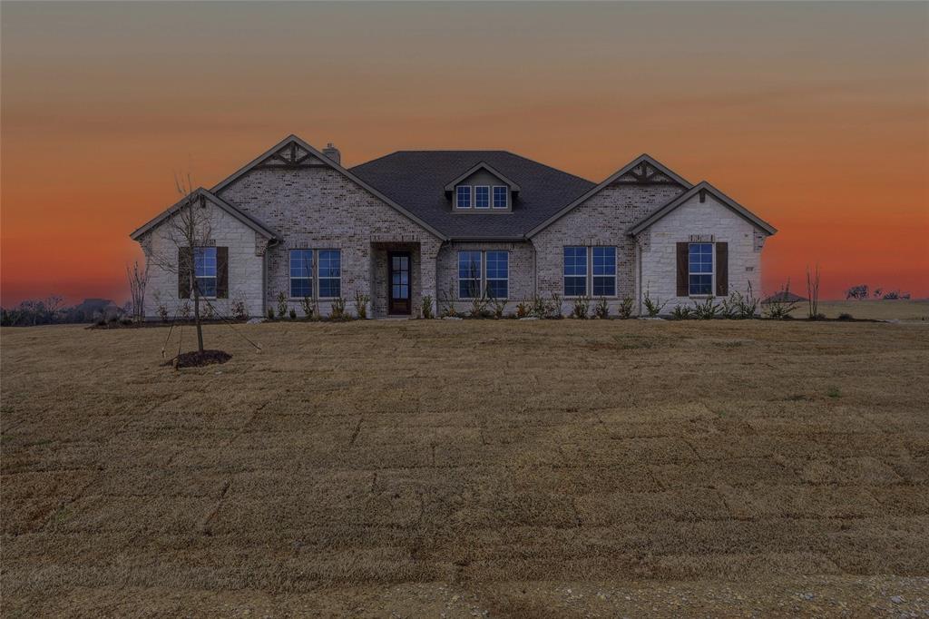 View of front of property with a front yard and brick siding