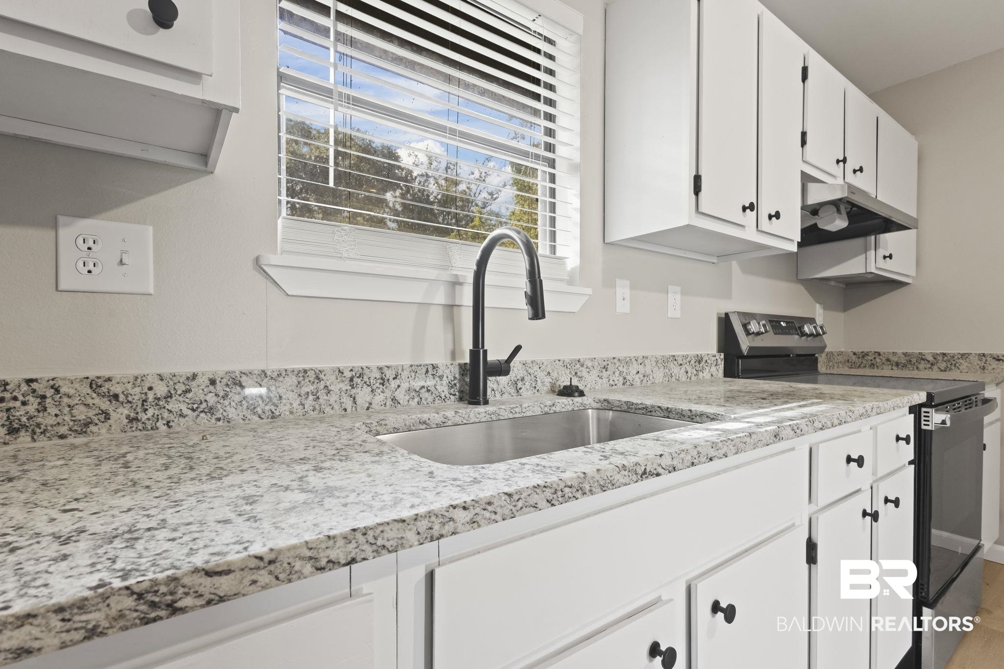 309 West Roosevelt Avenue Foley, AL 36535 - Photo 9 of 60 Kitchen with white cabinets, stainless steel electric range, light wood-type flooring, and sink