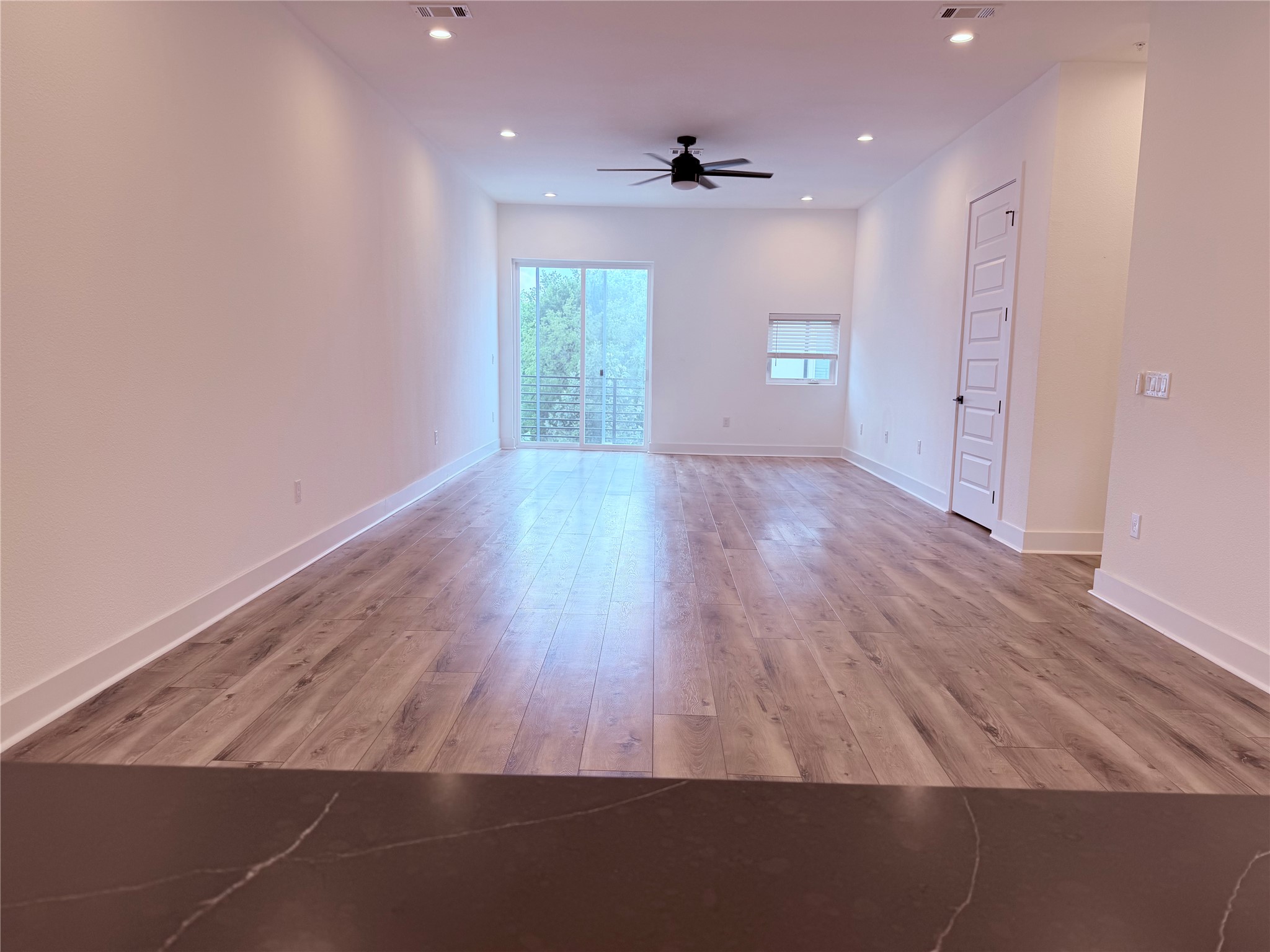 1417 Kramer Lane, Unit 7 Austin, TX 78758 - Photo 16 of 24 A spacious room features rich wood flooring, high ceilings, and sliding glass doors leading to a private balcony.