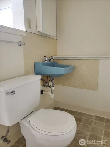 a bathroom with a toilet a sink and a mirror