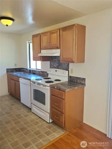a kitchen with stainless steel appliances granite countertop a stove a sink and a microwave