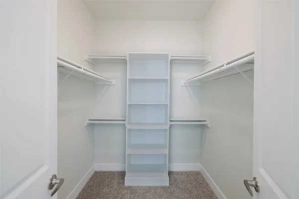 a view of walk in closet with empty racks