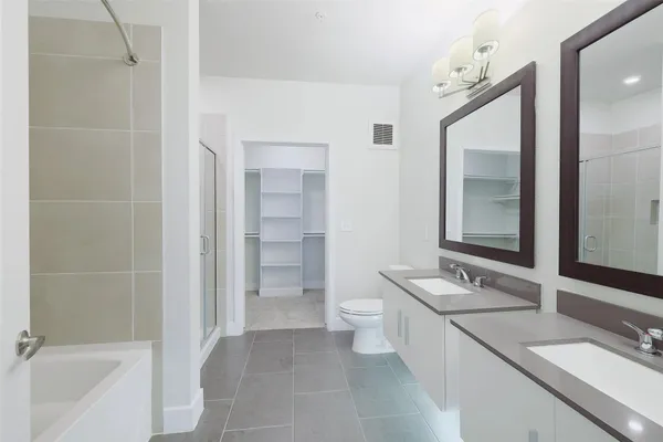 a bathroom with a granite countertop sink mirror and a bathtub