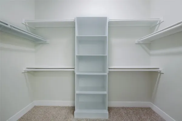 a view of walk in closet with empty racks
