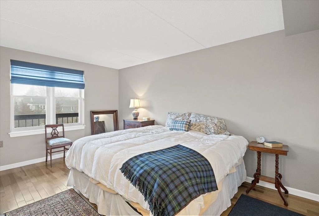 155 George Washington Boulevard, Unit 707 Hull, MA 02045 - Photo 16 of 24 a bedroom with a bed a table and windows