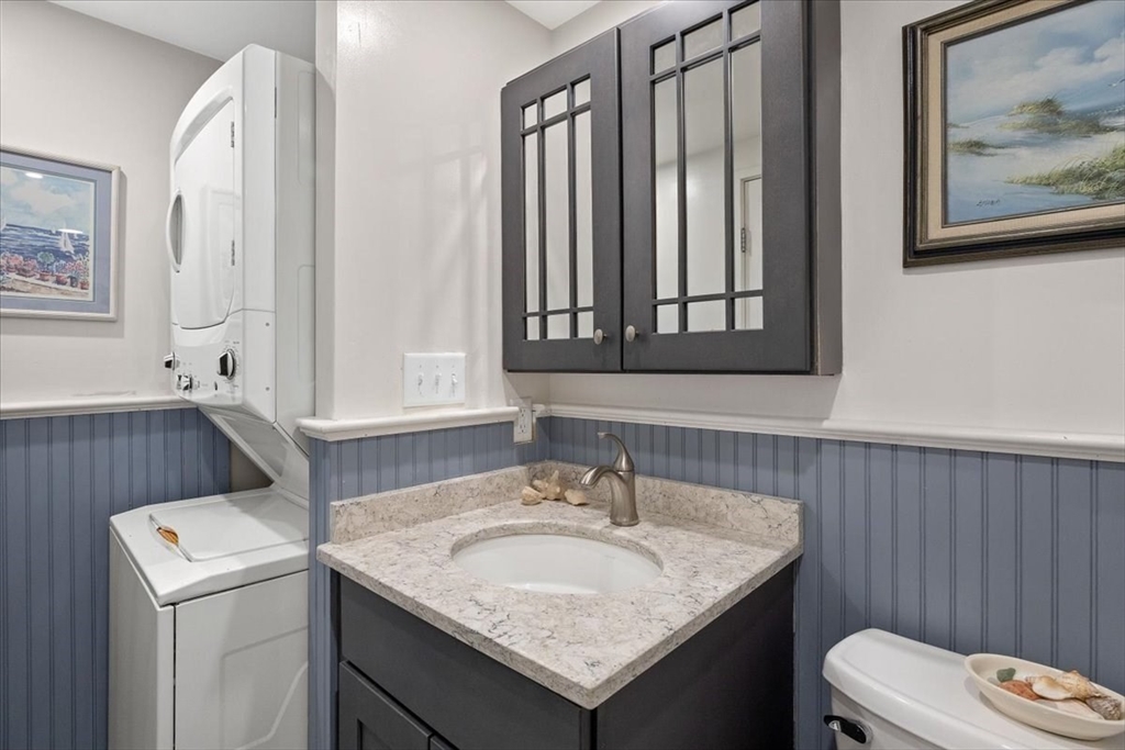 155 George Washington Boulevard, Unit 707 Hull, MA 02045 - Photo 19 of 24 a bathroom with a granite countertop sink and a toilet