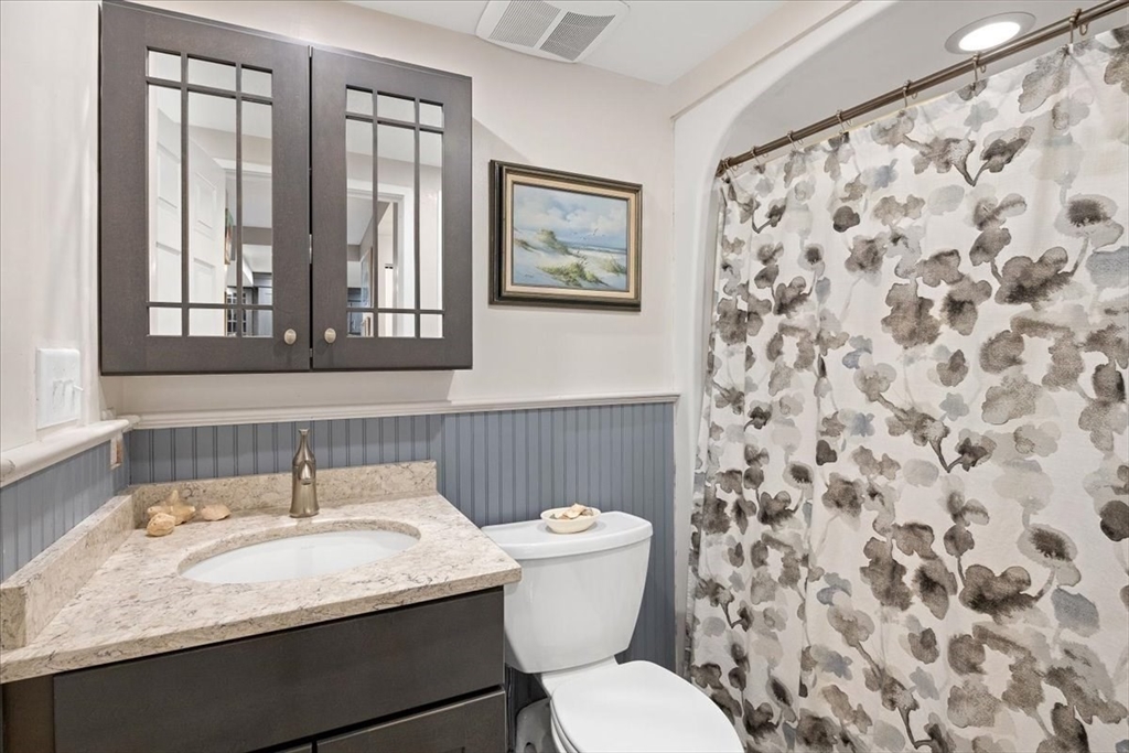 155 George Washington Boulevard, Unit 707 Hull, MA 02045 - Photo 20 of 24 a bathroom with a granite countertop sink and a toilet