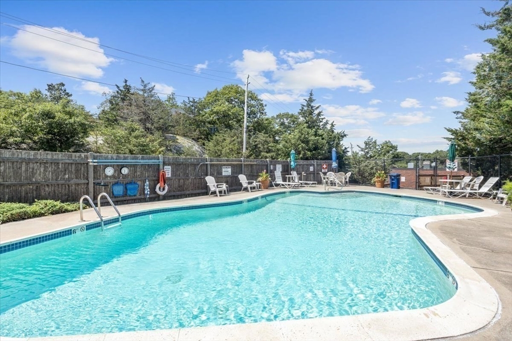 155 George Washington Boulevard, Unit 707 Hull, MA 02045 - Photo 23 of 24 a view of a swimming pool with a table and chairs
