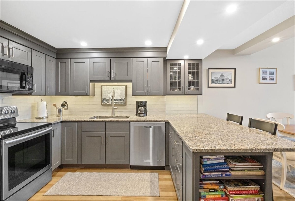 155 George Washington Boulevard, Unit 707 Hull, MA 02045 - Photo 4 of 24 a kitchen with stainless steel appliances granite countertop a sink dishwasher stove and oven