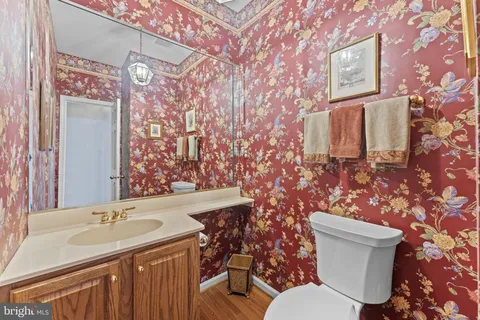 a bathroom with a granite countertop toilet sink and mirror
