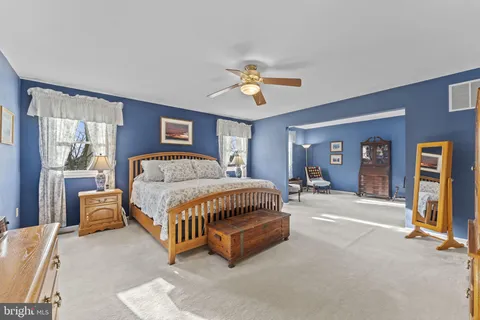 a spacious bedroom with a bed couch and window